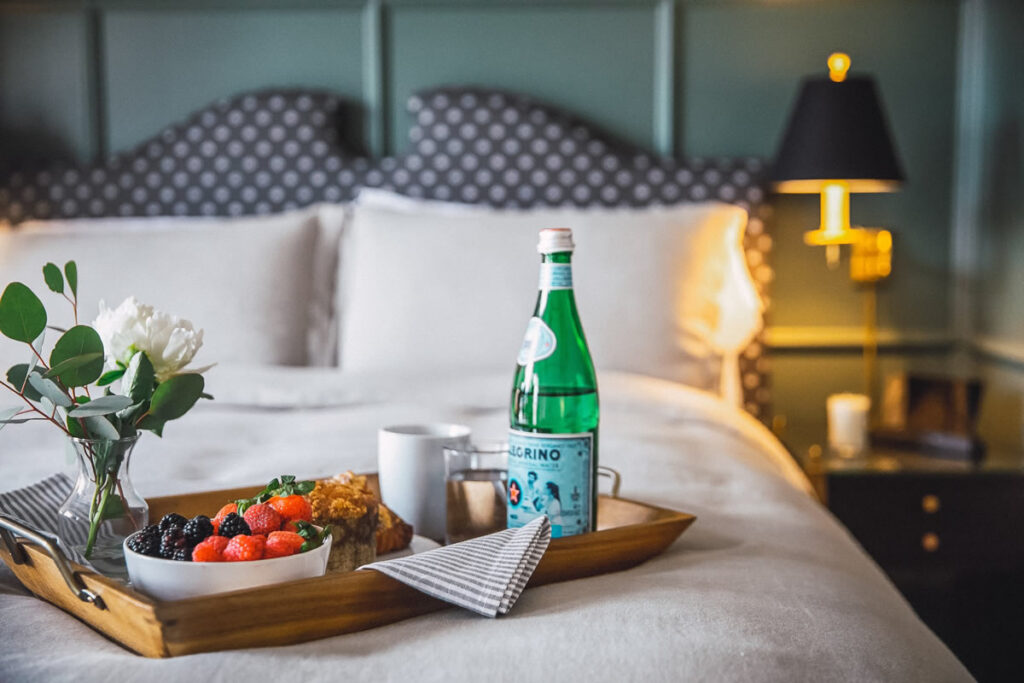 Fruit bowl and sparkling water bowl on bed